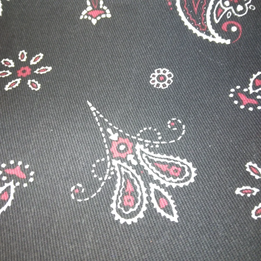 FABRIC Red and white paisley print on black background, twill weave